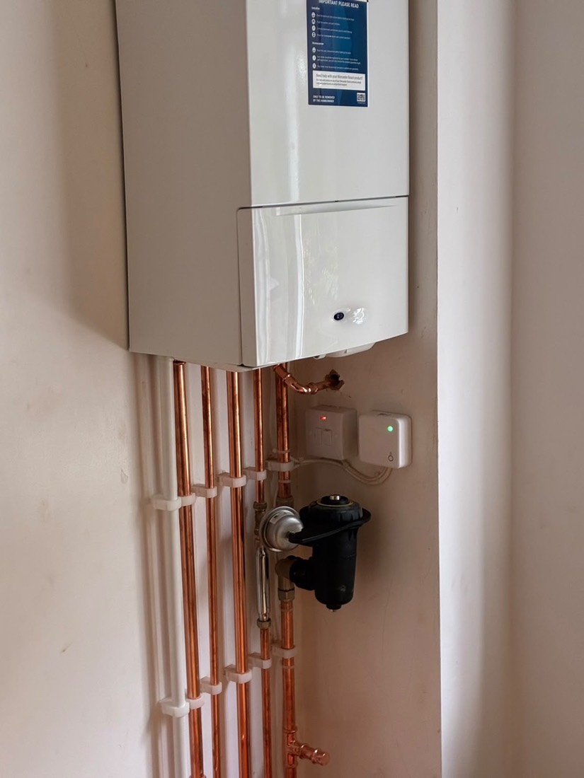 A newly installed Worcester Bosch boiler with the magnetic filter and smart control receiver fitted alongside new copper pipework